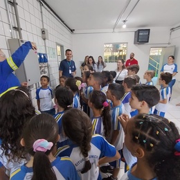 Operadora de ETA demonstrando análise de controle de qualidade da água aos alunos da EMEF Paulo Freire